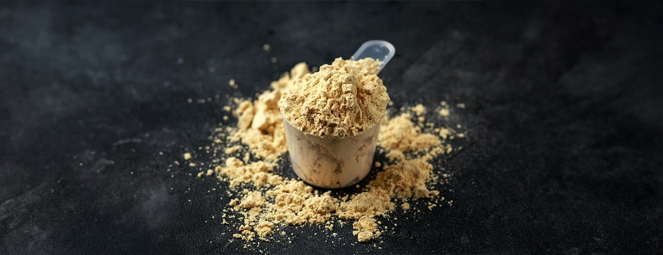 Eine Portion Maca-Pulver auf schwarzem Hintergrund