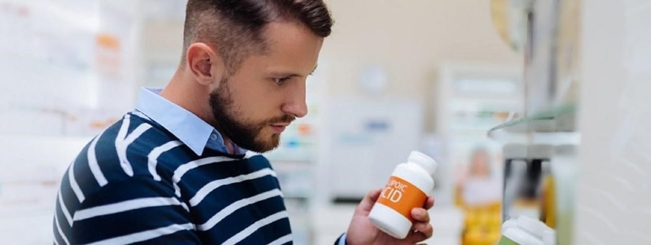 En mand, der v&aelig;lger receptfri medicin p&aring; apoteket.