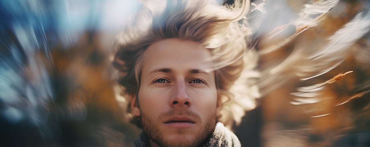 Portr&auml;t eines gut aussehenden jungen Mannes mit fliegenden blonden Haaren im Herbstpark
