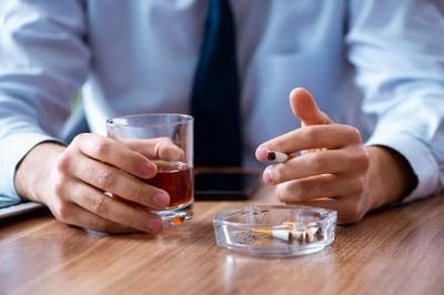 Homem a fumar e a beber &aacute;lcool