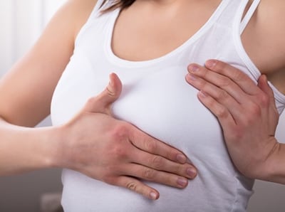 Eine Frau, die ihre Brust ber&uuml;hrt und tastet