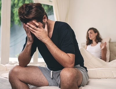 Um casal que discute na cama devido &agrave; disfun&ccedil;&atilde;o er&eacute;til do homem.