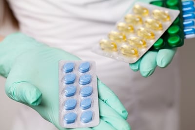 Um m&eacute;dico que oferece comprimidos para a pot&ecirc;ncia para a disfun&ccedil;&atilde;o er&eacute;ctil