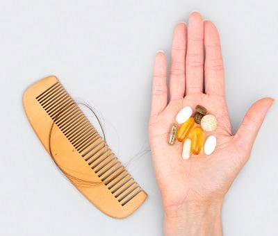  M&auml;nnliche H&auml;nde halten Ampullen mit Vitaminen f&uuml;r den Haarwuchs