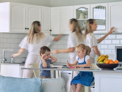 Viel besch&auml;ftigte Mutter, die ihre Kinder f&uuml;ttert und das Haus putzt