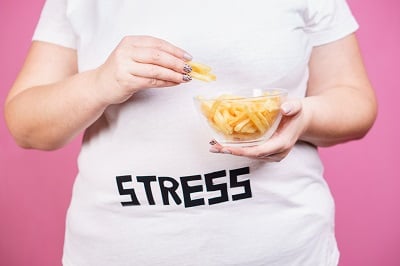 Ein M&auml;dchen isst Fast Food, weil sie gestresst ist