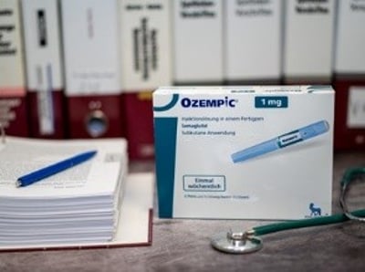 Uma embalagem de Ozempic ao lado de um estetosc&oacute;pio e de uma pilha de documentos m&eacute;dicos
