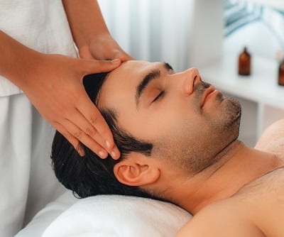 Ein Mann genie&szlig;t eine Kopfmassage und verw&ouml;hnt die Gesundheit seiner Haare.