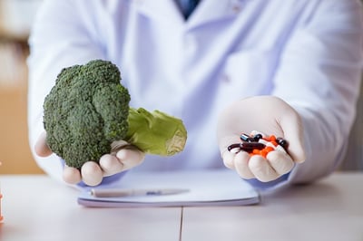 Arzt schl&auml;gt gr&uuml;nes Gem&uuml;se und medikament&ouml;se Behandlung von &Uuml;bergewicht vor