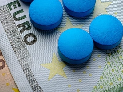 Blaue Pillen mit Euro-Banknoten